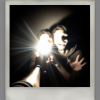 Make this image of two people look like it was taken with a Polaroid camera. There should be no obvious subjects or props. It should look like a random shot captured by chance. The image should appear like a snapshot without any special attention. Include a slight motion blur and light from the camera flash in a dark area that spreads evenly throughout the photo. Don’t distort the face. Change the background behind the two people to a white curtain. The guy should be touching my face.