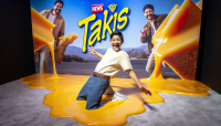 Un photoportunity en un evento publicitario de la marca Takis en donde un chico está simulando estar hundido hasta la cintura en un piso de queso fundido. La actitud del chico tiene que ser complice, estar riéndose, disfrutando de que le saquen una foto en ese evento de lanzamiento de la marca
